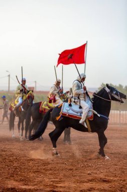 Essaouira, Fas - 13 Ağustos 2023: Biniciler geleneksel Fas kıyafeti ve şövalyelerin aksesuarları içinde Arapça Tbourida adlı geleneksel bir giysi etkinliğine katılıyorlar