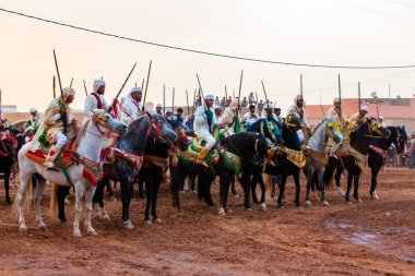 Essaouira, Fas - 13 Ağustos 2023: Biniciler geleneksel Fas kıyafeti ve şövalyelerin aksesuarları içinde Arapça Tbourida adlı geleneksel bir giysi etkinliğine katılıyorlar