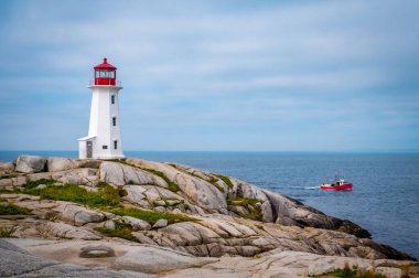 Kırmızı balıkçı teknesiyle Iconic Peggys Koyu Deniz feneri, Nova Scotia, Kanada. Fotoğraf Eylül 2023 'te çekildi..
