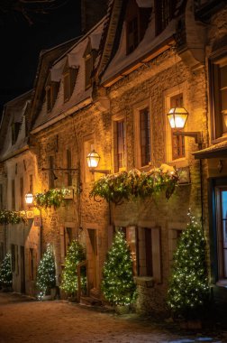 Eski aşağı kasabadaki tarihi kaldırım taşı caddesi, geceleyin aydınlatılmış ve kış tatillerinde Noel süslemeleri ile süslenmiş, Petit-Champlain bölgesi, Quebec City, Kanada Aralık 2022.