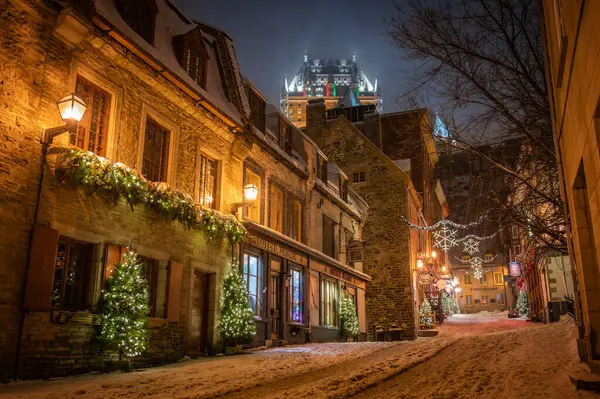 Eski Quebec 'in Petit-Champlain Bölgesi' ndeki Sous-le-Fort Caddesi, Noel kış tatili süslemeleriyle aydınlatılmış, Fairmont Chateau Frontenac Oteli, Quebec City, Kanada Aralık 2022.