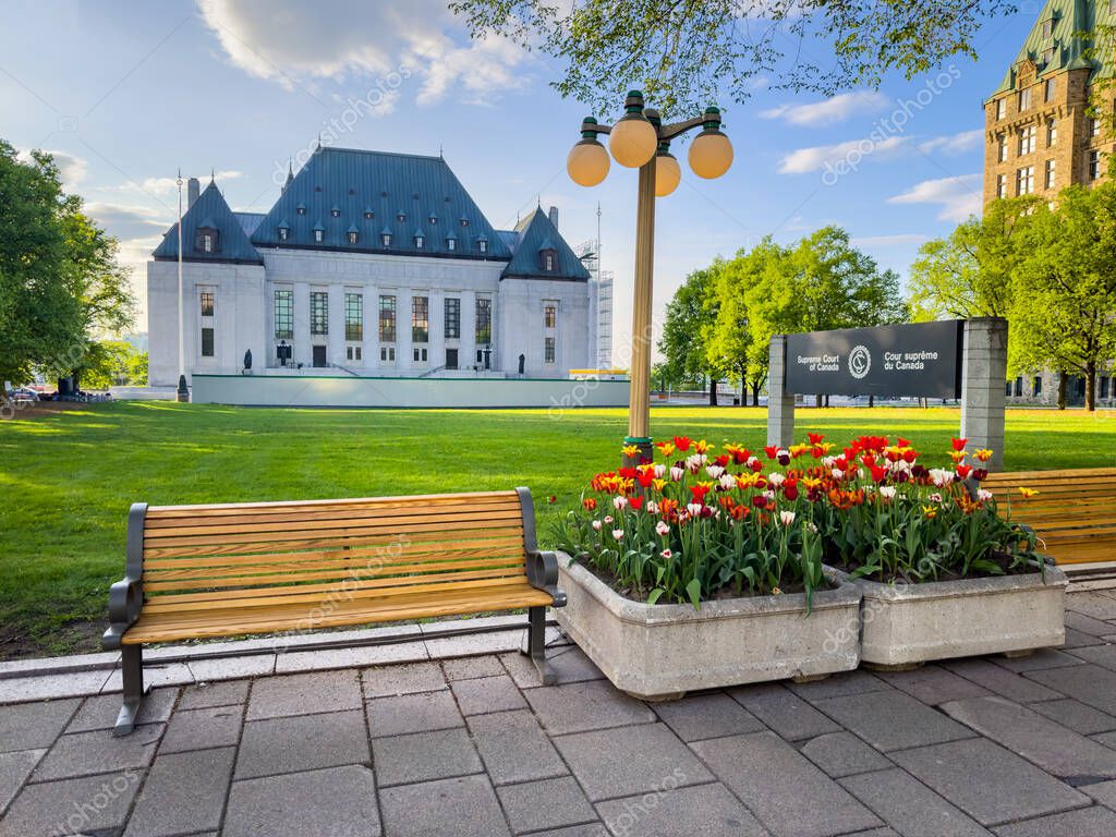 Tulips, benches and lamp post in front of the Supreme Court of Canada courthouse building, during the Canadian Tulip Festival on a beautiful spring evening, Ottawa, Ontario, Canada May 2024.