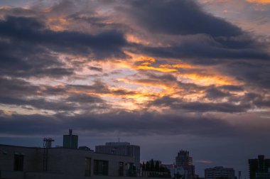 Yağmur fırtınasından sonra gün batımında dramatik karamsar bulutlar, Ottawa, Ontario, Kanada şehir merkezinde güneş ışığı bulutları delip geçiyor. Yağmurdan sonra, güzel hava. Fotoğraf, Haziran 2024 'te çekilen umudu simgeliyor..