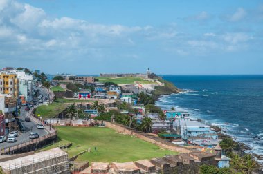 Eski San Juan, Porto Riko 'nun canlı manzarası, La Perla' nın renkli binaları, Castillo San Felipe del Morro 'nun tarihi tahkimatları, mavi gökyüzünün altındaki okyanus kıyıları, Mart 2025