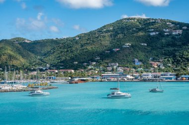 İngiliz Virgin Adaları, Tortola 'daki Road Town limanının güzel manzarası, yelkenliler, turkuaz Karayip suları, renkli yamaç evleri, ve mavi bir gökyüzü altında yemyeşil dağlar Şubat 2025