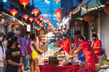 CHONBURI İspatlama, Tayland - 11 Haziran 2022. Akşamları 100 yıllık Çin marketi. İnsanlar kalabalık bir tezgahtan yiyecek satın alır. Ban Chak Ngaew pazarı, Covid-19 'un bir yıllık kapanışından sonra nihayet hayata döndü..