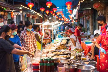 CHONBURI İspatlama, Tayland - 11 Haziran 2022. Akşamları 100 yıllık Çin marketi. İnsanlar kalabalık bir tezgahtan yiyecek satın alır. Ban Chak Ngaew pazarı, Covid-19 'un bir yıllık kapanışından sonra nihayet hayata döndü..
