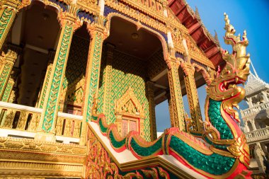 PATTAYA, THAILAND 20 HAZİRAN 2022. Wat Nong Yai tapınağı. Öndeki Tayland ejderhası heykeli. Renkli yaldızlı desenli tapınağın ön cephesi.