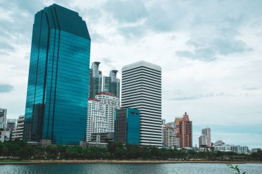 Göl manzaralı ve gökdelenli Benchakitti parkı manzarası. Bangkok, Tayland.