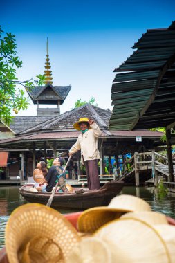 PATTAYA, THAILAND - 22 Haziran 2022. Pattaya Yüzen Pazarı. Yüzen bir teknenin POV görüntüsü. Dost canlısı kayıkçı gülümser ve el sallar.