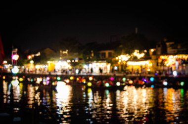 Canlı bir nehir kenarı kasabasının gece manzarası. Yumuşak ve kasıtlı bir bulanıklıkla çekilmiş.. 