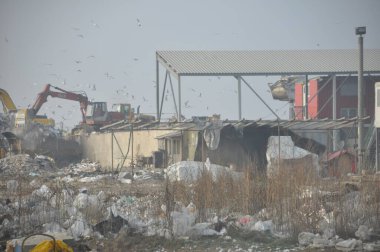 Arkasında buldozer ve buldozer olan bir bina.