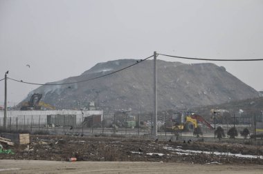 Arkasında dağ olan bir inşaat alanı.