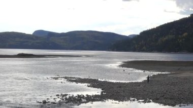 Huzurun ve görkemli gölün manzarasının tadını çıkaran adam.