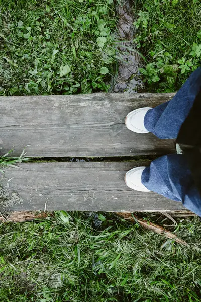 Beyaz ayakkabılı kadın ormanda duruyor..