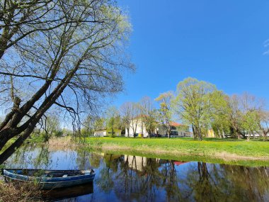 Beautiful landscape with blue boat on the lake. clipart