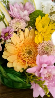 Masanın üzerinde sarı ve mor çiçekler var.