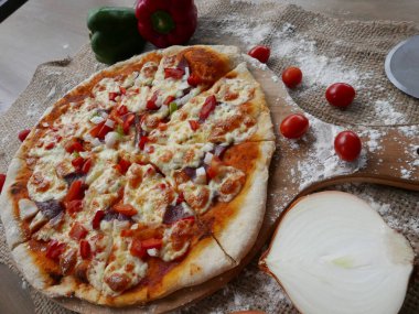 Bu profesyonel fotoğraf mükemmel bir pizza başyapıtının özünü yakalıyor. Kompozisyon göz kamaştırıcı, pizza basit bir arkaplan karşısında odak noktası konumunda..