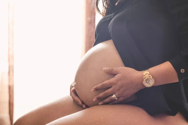 Беременная Молодая Женщина Сидит Руками Животе Черной Блузке Нижнем Белье — стоковое фото