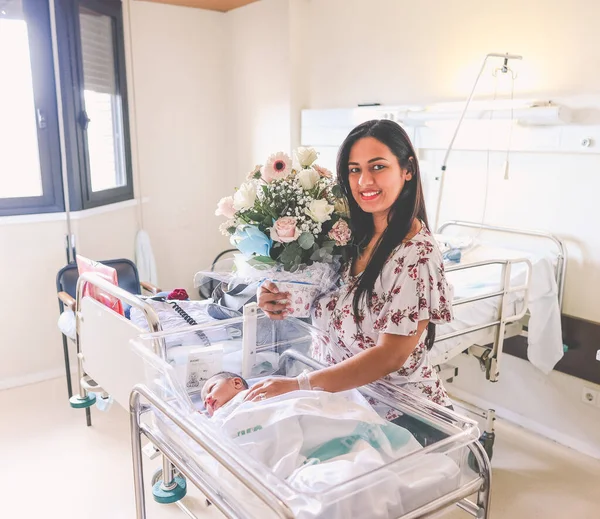 Latina Neben Ihrem Neugeborenen Krankenhaus Lächelnd Und Mit Einem Blumenstrauß — Stockfoto
