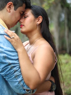 Heteroseksüel çift doğada romantik bir şekilde sarılıyor.