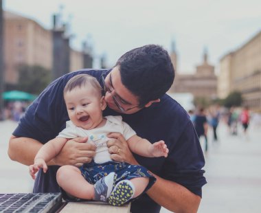 Bebek ve babası gülümsüyor, gün içinde şehirde dolanıp sarılıyorlar.