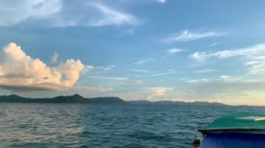 Güneşin batışını ve tekneden gökyüzündeki bulutları görüyorum.