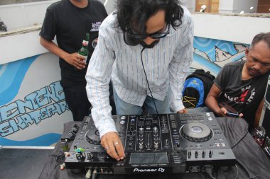 Asyalı bir adam go-board günü kutlamasında DJ 'lik yapıyor. Endonezya - Medan, 21 Haziran 2024