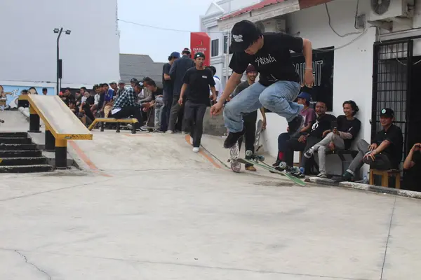 Asyalı bir adam kaykayla numaralar yapıyor..