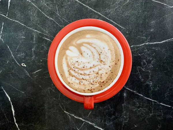 Siyah masada bir fincan kapuçino.