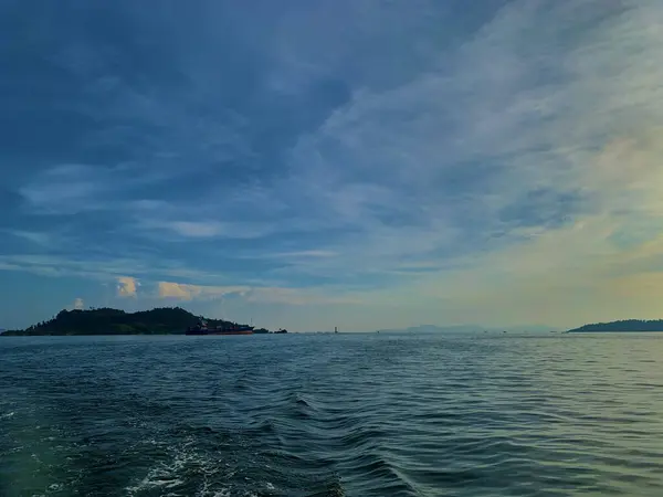 Okyanusta küçük bir adası olan bir tekne.