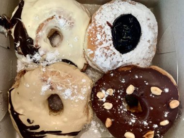 a box of donuts with powdered sugar and chocolate. clipart