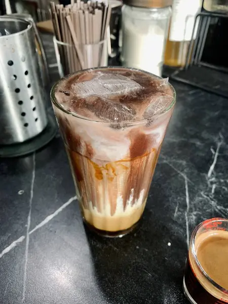 Bir bardak çikolatalı buzlu kahve ve küçük bir fincan kahve..