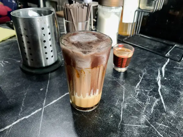 Bir bardak çikolatalı buzlu kahve ve küçük bir fincan kahve..