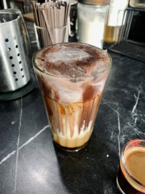 Bir bardak çikolatalı buzlu kahve ve küçük bir fincan kahve..