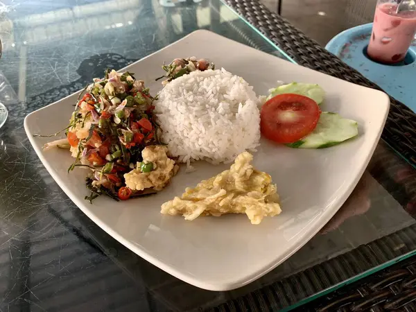 Üstünde pirinç ve sebze olan beyaz tabak..