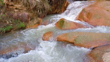 Kayaların arasından akan nehir suyunun ferahlatıcı görüntüsü