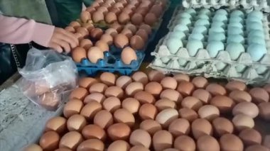 Alıcılar Endonezya 'nın Muntok şehrindeki geleneksel pazardan yumurta seçiyorlar.
