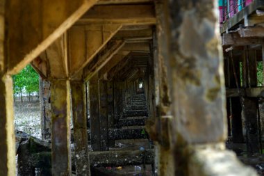 Gündüzleri Belo Laut Köyü 'nde kumsalda inşa edilen, sağdan gelen sütunlar veya beton iskele sütunları.