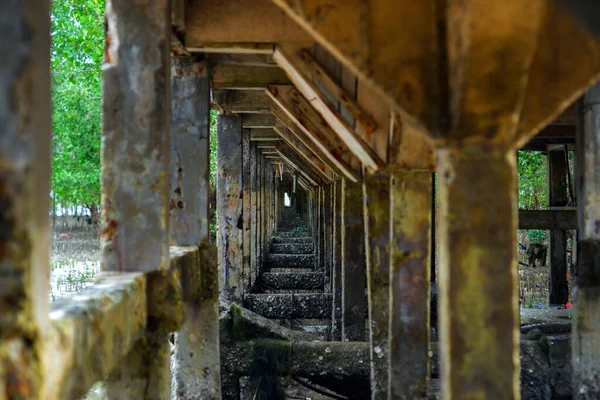 Gündüzleri Belo Laut köyünde, sahilde inşa edilmiş, soldan bir iskelenin sütunları ya da beton sütunları.