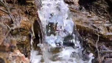 Öğleden sonra Belo Laut köyünde çamurlu bir yüzeyden küçük bir şelale akıyor.