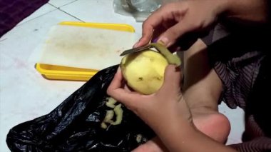 Geceleri patates soyan Asyalı bir kadının etkinliği.
