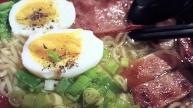 İki yarısı yumurta, et ve sebzeli Ramen Eriştesi.