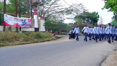 MUNTOK, INDONEZYA - 14 Eylül 2023: Endonezya Bağımsızlık Günü 'nde lise öğrencileri beyaz üniforma ve mavi pantolon içinde sıraya dizildi