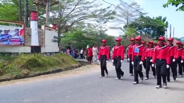 MUNTOK, INDONEZYA - 14 Eylül 2023: Kırmızı ve Siyah Üniformalı lise öğrencileri, Askerler Endonezya 'nın Bağımsızlık Günü' nü kutlamak için yürüyorlar