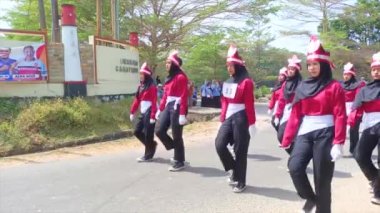 MUNTOK, İNDONEZYA - 14 Eylül 2023: Endonezya Bağımsızlık Günü 'nde Kırmızı ve Siyah Üniforma Giyen Ortaokul Öğrencileri İçin Yürüyen Yarışma