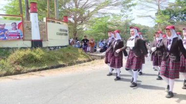 MUNTOK, INDONEZYA - 14 Eylül 2023: Kahverengi Ceketli Lise Öğrencilerinin Yürüyüşü, Endonezya Bağımsızlık Günü Geçit Töreni 'nde ekose etekler