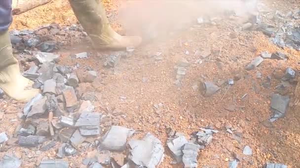 日中に鉄の爪を使用して地面に熱い炭を集める労働者 — ストック動画