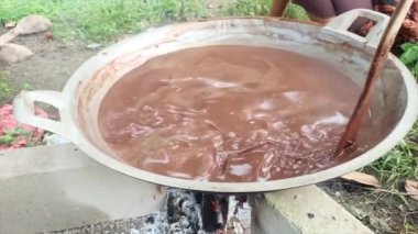 Bir kadının elleri ateşte çikolatalı puding karışımını karıştırıyor.
