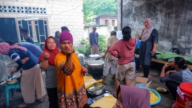 MUNTOK, INDONEZYA - 17 Nisan 2023: Halka açık bir mutfakta yemek pişiren kadınların etkinlikleri ve etkinlikleri, bir aile Şükran Günü etkinliği